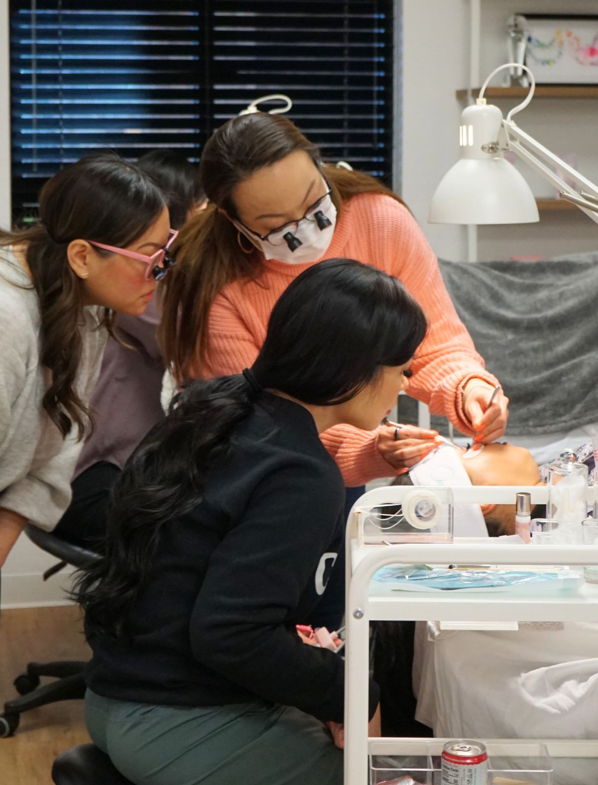 Lash artists examining lashes during a lash training session